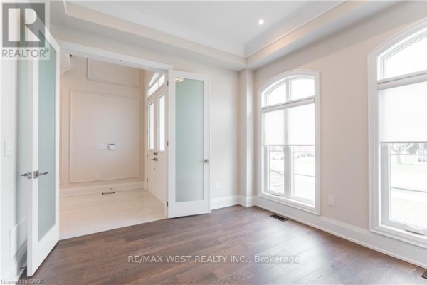 Interior view of a room with hardwood floors connecting to a staircase. - 119 Jay Street, Toronto