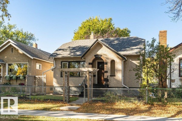 Exterior view of the house from the left, showing the driveway and front yard. - 11910 94 St Nw, Edmonton