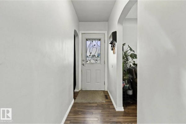 Interior front entrance hallway with light grey walls, a glass-paned door, and dark wood laminate flooring. - 11928 127 St Nw, Edmonton