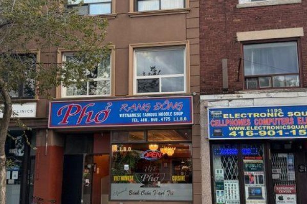 Street view of commercial buildings with storefronts and traffic on St Clair Avenue West. - 1193 St Clair Avenue W, Toronto