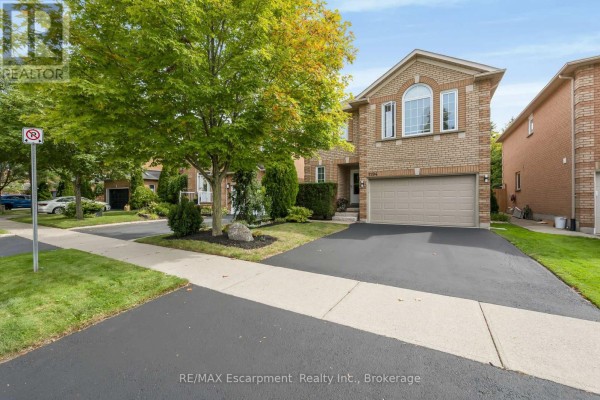 View of the house from the street showing driveway, lawn, and neighboring homes. - 1194 Old Oak Drive, Oakville