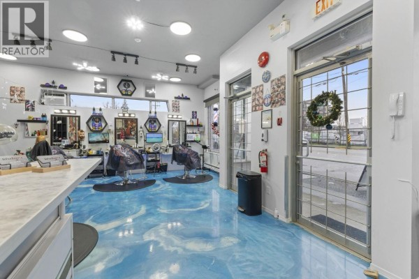 Salon space featuring seating, barber stations, and colorful wall art - 11940 228 Street, Maple Ridge