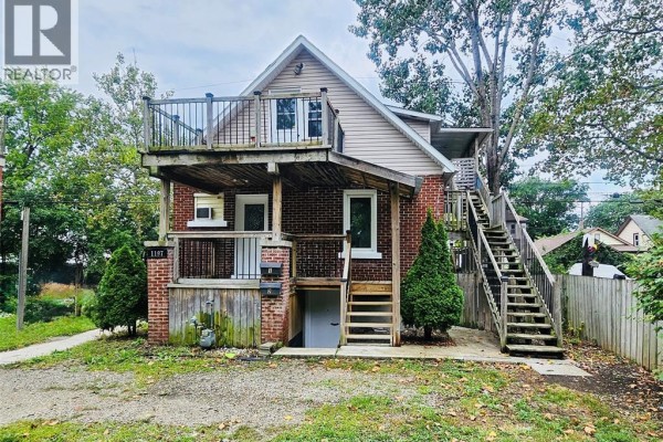 Close-up front view of duplex with brick facade and wooden porch. - 1197 Albert, Windsor