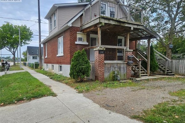 Side view of duplex showing brick exterior, concrete walkway, and driveway. - 1197 Albert, Windsor
