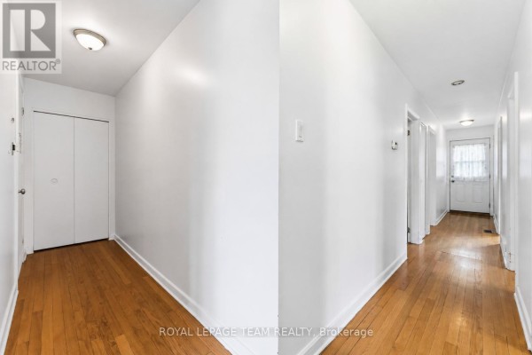 Interior hallway with hardwood floors, white walls, and a large closet. - 1197 Maitland Avenue, Ottawa