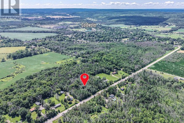 Aerial view of a wooded property marked with a red pin, located near Coldwater and surrounded by fields. - 1197 Upper Big Chute Road, Severn