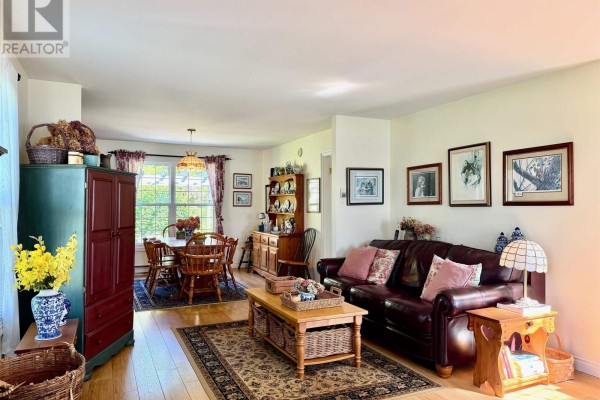 Living and dining area with wooden furniture, leather sofa, and a fireplace. - 1199 Raynardton Road, Raynardton