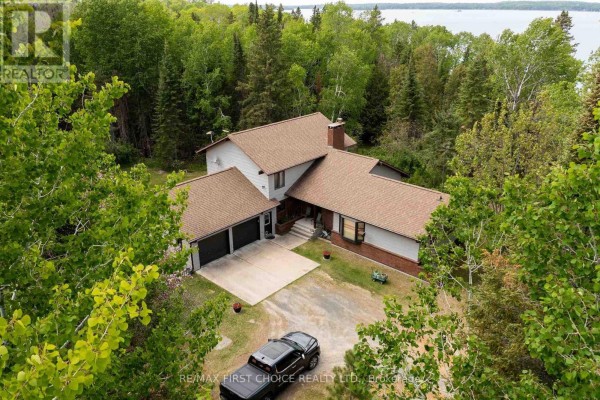 Front view of the house with a driveway, two-car garage, and landscaped yard. - 11a Lebrons Road, Sioux Narrows Nestor Falls