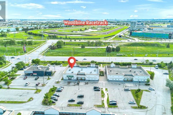 Aerial view of commercial buildings near Woodbine Racetrack with a red marker. - 12 - 120 Queen Plate Drive, Toronto