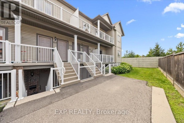 Ground-level view of the apartment building's side with stairs leading down to entrances and a grassy area. - 12 - 128 Sternes Private, Ottawa