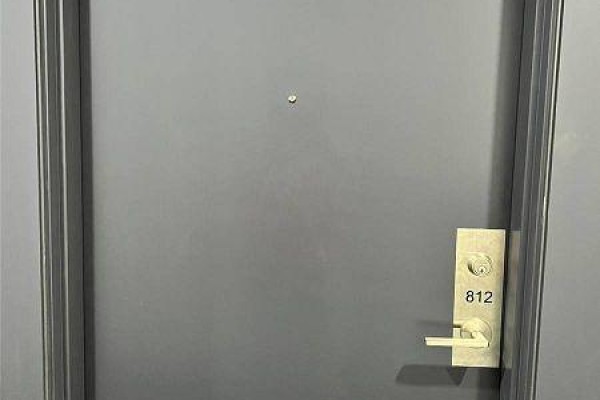 Close-up of a grey apartment door with a brass handle, peephole, and unit number 812. - 12 - 3237 Bayview Avenue, Toronto
