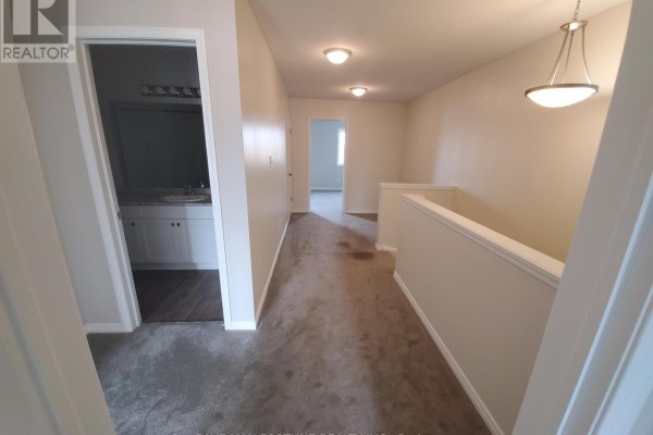 Hallway on the upper level with beige walls and grey carpet flooring. - 12 - 50 Pinnacle Drive, Kitchener