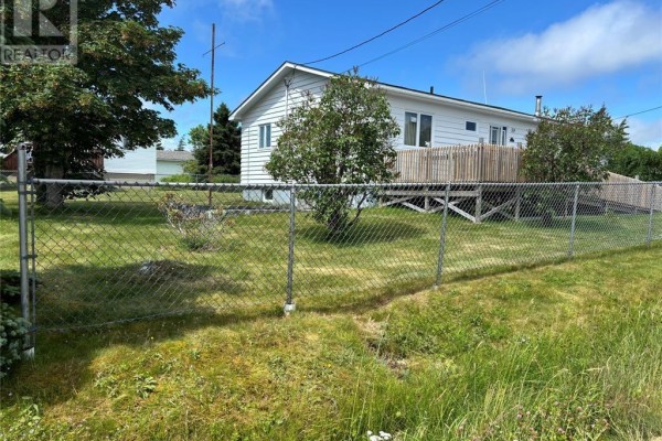 Bedroom with floral wallpaper, wood laminate floor, and a window with water view. - 12-14 Barnes Road, Bay Roberts