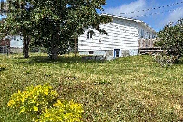 Exterior view of a white vinyl-sided house with a dry grassy yard. - 12-14 Barnes Road, Bay Roberts