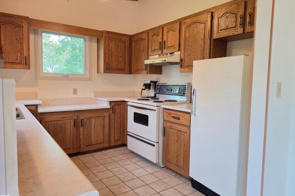 Kitchen with light wood cabinets, white appliances including a stove and refrigerator, and a window. - #12 53220 Rge Road 15, Rural Parkland County