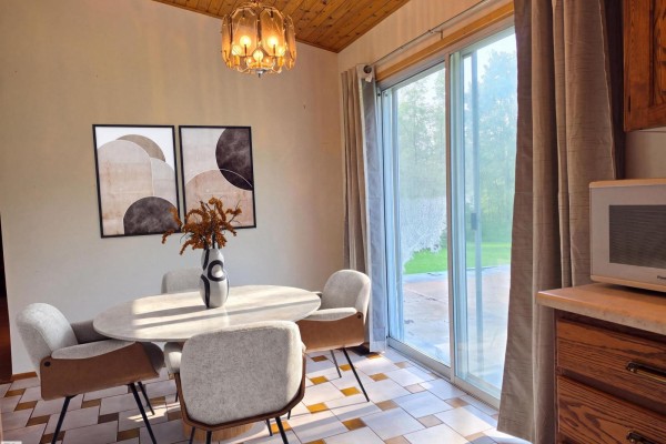 Dining area with a round table, four chairs, a sliding glass door to the backyard, and decorative art. - #12 53220 Rge Road 15, Rural Parkland County