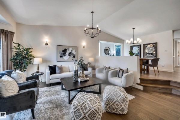 Spacious living area with vaulted ceiling, wood floors, and a raised step. - 12 A Invermere Pl, St  Albert