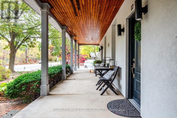 Covered porch with wood ceiling, columns, and outdoor seating with a street view. - 12 Adamson Street N, Halton Hills