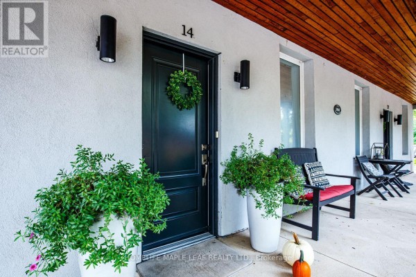 Entrance door with wreath, planters, and outdoor seating on the covered porch. - 12 Adamson Street N, Halton Hills