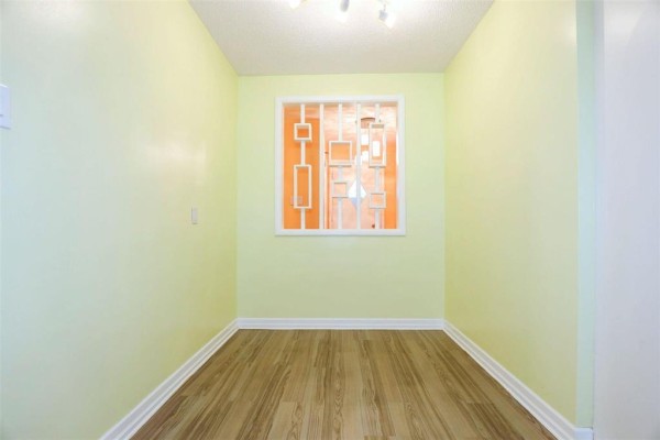 Small room with light green walls, wood-look flooring, and decorative window screen. - 12 Barberry Road, Winnipeg