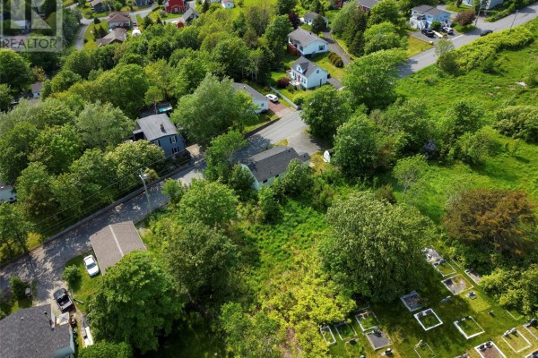 Aerial view of the undeveloped lot in the foreground, with houses and a cemetery in the background. - 12 Bemisters Hill, Carbonear