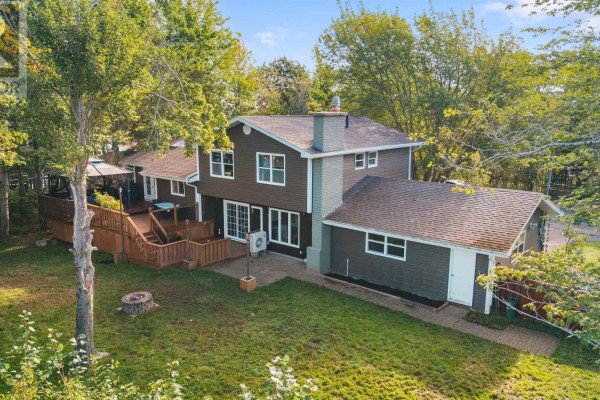 Aerial view of the rear of the house, showcasing the deck, patio, and surrounding greenery. - 12 Birch Hill Drive, Stellarton