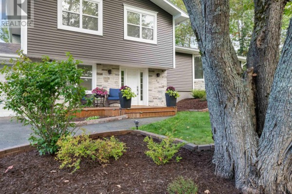 Close-up of the house entrance with a wooden walkway, stone accents, and landscaping. - 12 Birch Hill Drive, Stellarton