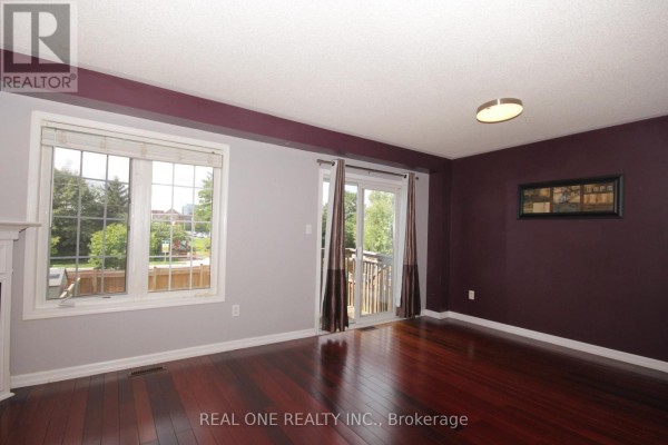 Living space with two chairs, a television, and two windows. - 12 Bonello Crescent, Whitby