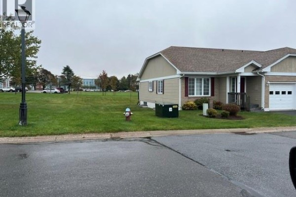 Front exterior of a garden home with a lawn, sidewalk, and street. - 12 Caitlin Court, Saint John