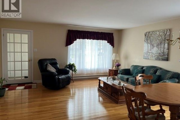 Living room with a recliner, sofa, French doors, and hardwood floors. - 12 Caitlin Court, Saint John