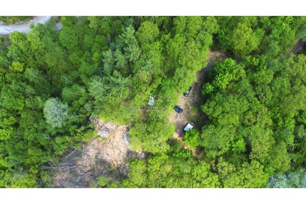 Overhead view of a wooded area with vehicles parked on a dirt path amongst the trees. - 12 Ch. Du Mica, Val Des Monts