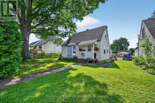 View of a manicured front lawn and sidewalk leading to the house entrance. - 12 Churchill Crescent, Smiths Falls