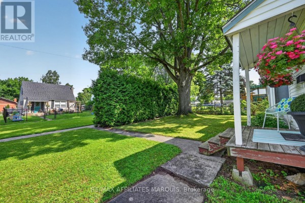 Exterior of a white bungalow with white siding and a dark shingled roof. - 12 Churchill Crescent, Smiths Falls