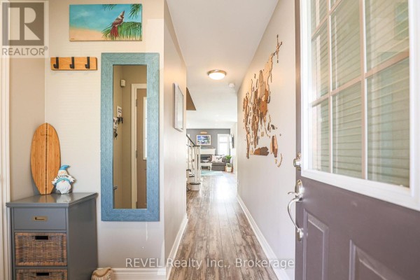 Foyer with gray walls, wood-look flooring, and a surfboard on a cabinet. - 12 Colonel Lyall Street, St  Catharines