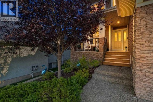 Front entrance walkway and porch of a Calgary home with stone accents and double front doors. - 12 Crestridge Rise Sw, Calgary