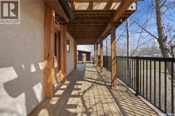 Wooden deck with a black railing, showing light filtering through the wooden beams and posts. - 12 Finch Crescent, Thomson Lake