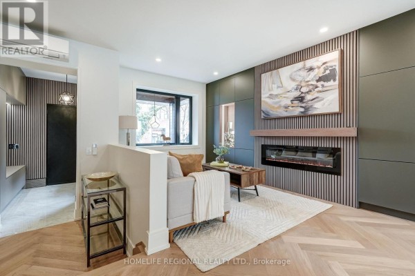 Living room with fireplace, neutral tones, and large window - 12 Macdonell Avenue, Toronto