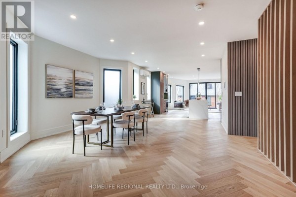Open-concept dining area with round table, hardwood flooring, and natural light - 12 Macdonell Avenue, Toronto