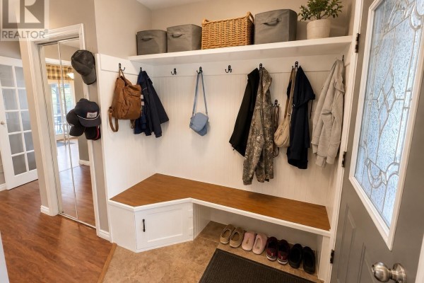 Mudroom with white beadboard walls, wooden bench, coat hooks, and shoe storage. - 12 Maple St, Wawa