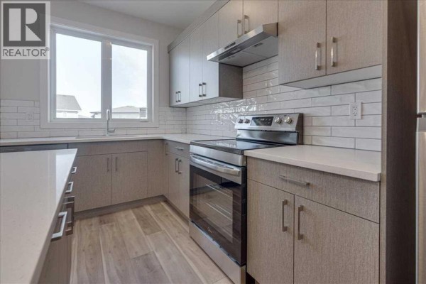 Bathroom with a white bathtub and a white countertop with sink. - 12 Memorial Parkway, Rural Red Deer County