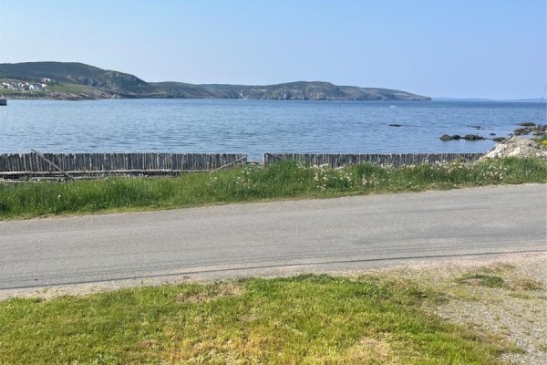 View of Bonavista Bay with a wooden fence and grassy embankment in the foreground. - 12 Mockbeggar Road, Bonavista
