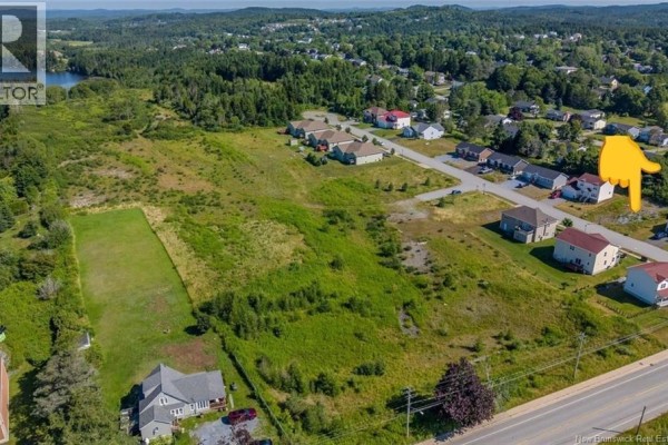 Aerial view of a large, undeveloped lot adjacent to residential housing in Saint John. - 12 Mosaic Drive, Saint John