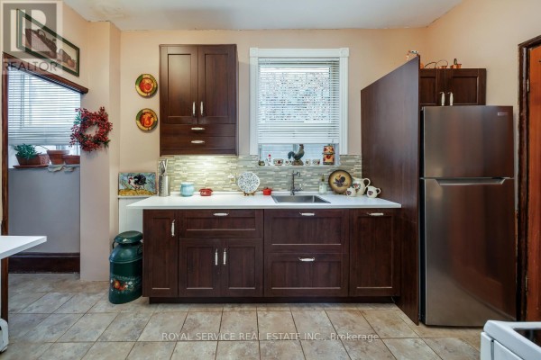 Entryway with tiled floor, vintage bench, and a door leading outside. - 12 Park Street, Port Hope