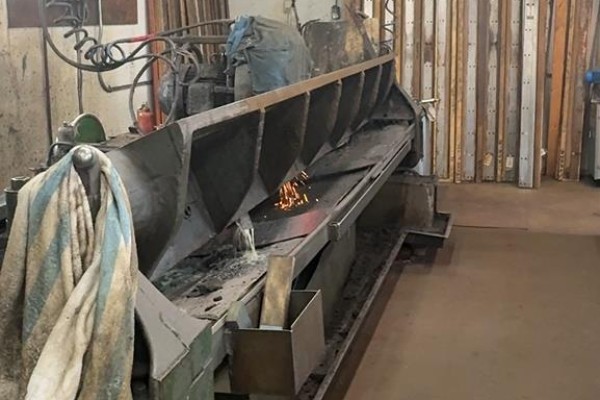 Industrial sharpening machine with sparks flying in a workshop setting - 12 Parkland Ave, Rural Ponoka County