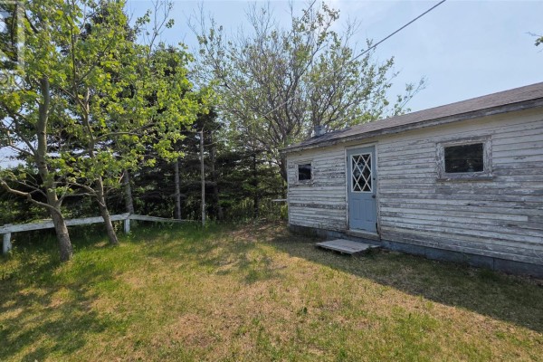 Exterior of a small white outbuilding with a gray door and two windows. - 12 Parsons Lane, Twillingate