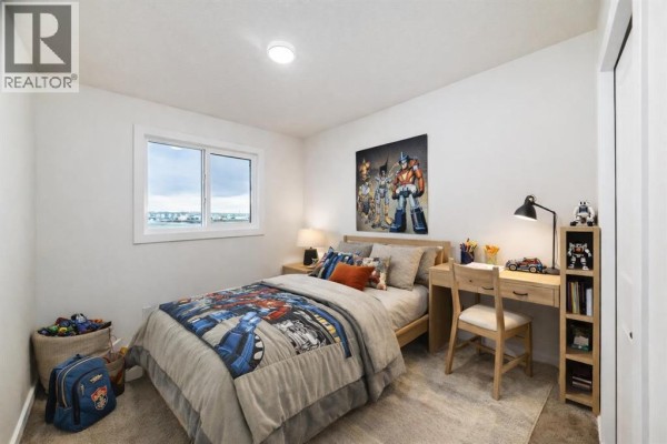 Child's bedroom with a twin bed, desk, and Transformers-themed bedding and decor. - 12 Savanna Place Ne, Calgary