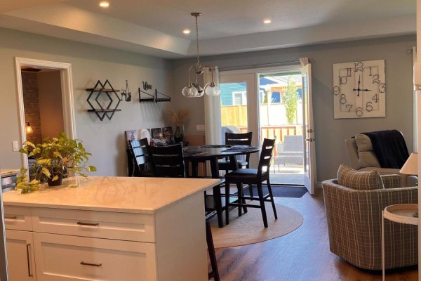 Open concept dining area with a dark wood table and chairs, leading to a deck. - 12 Sweetwater Drive S, Goderich)