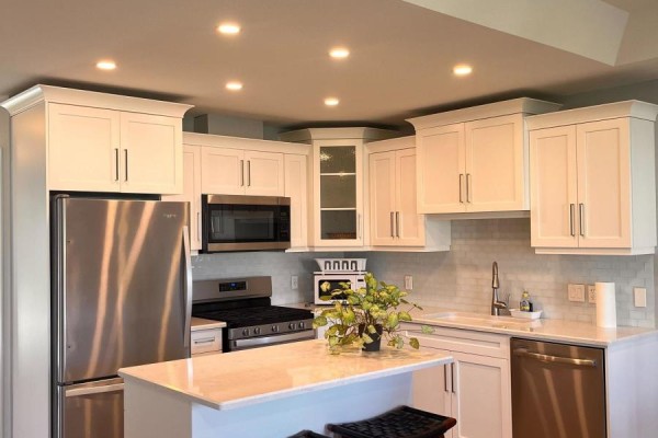 White shaker kitchen cabinets with stainless steel appliances and a marble island. - 12 Sweetwater Drive S, Goderich)