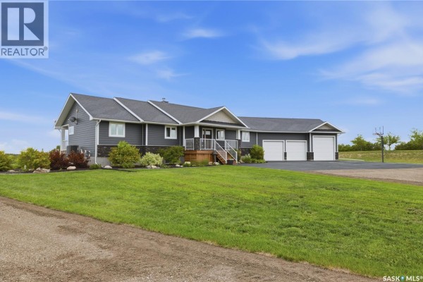 Exterior of a dark grey residential house with a paved driveway and a basketball hoop in the yard. - 12 Valley Ridge Road, Last Mountain Lake