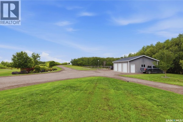 View of a detached grey three-car garage with a black pickup truck parked nearby on a gravel driveway. - 12 Valley Ridge Road, Last Mountain Lake